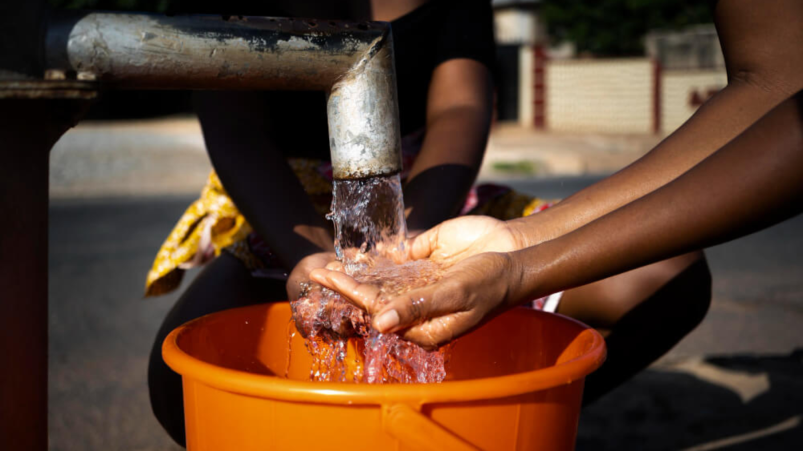 african-woman-pouring-water-recipient-outdoors (1)