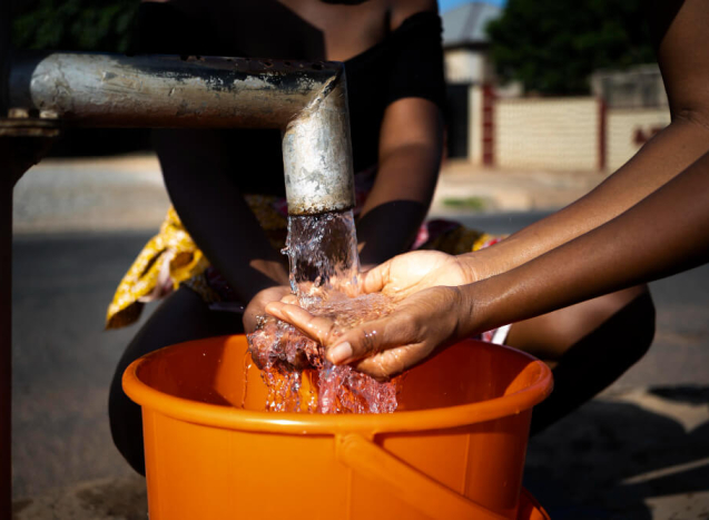 african-woman-pouring-water-recipient-outdoors (1)